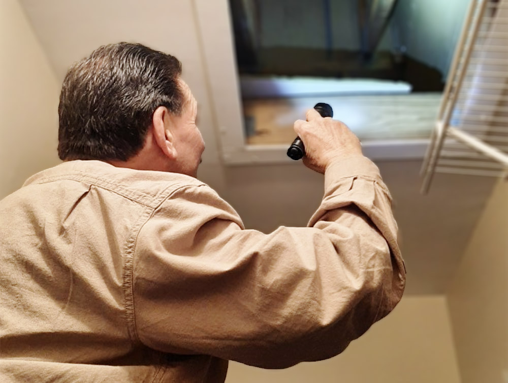 Steve Verger, one of our licensed home inspectors, inspecting an attic